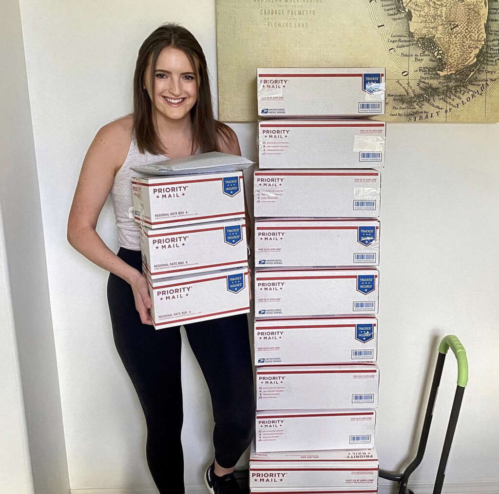 Nina from The Happy Hustlers Holding Packages Ready for Shipment